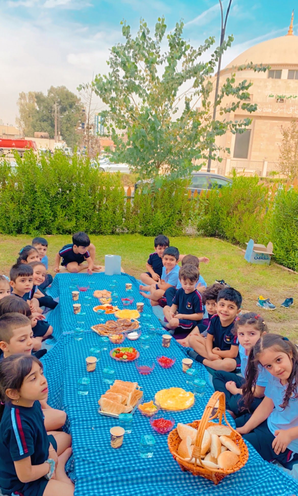 Sanny Kindergarten group of students sitting around a picnic table.