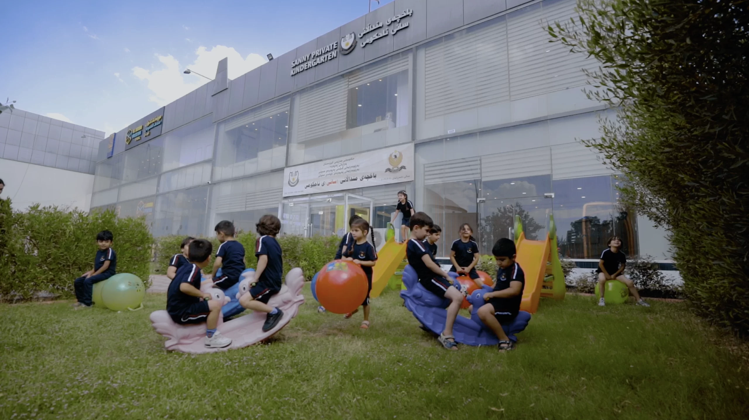 a group of children playing outside of Sanny Private Kindergarten Erbil building